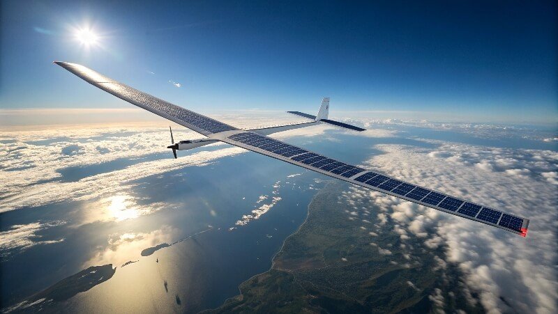 High-altitude solar drone flying above clouds with wings covered in solar panels reflecting sunlight.
